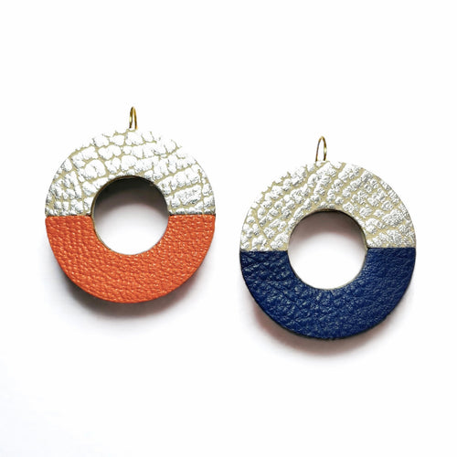 2 boucles d'oreilles, rondes en forme d'anneaux bicolores en cuirs argent et orange, et argent et bleu marine grainé sur fond blanc