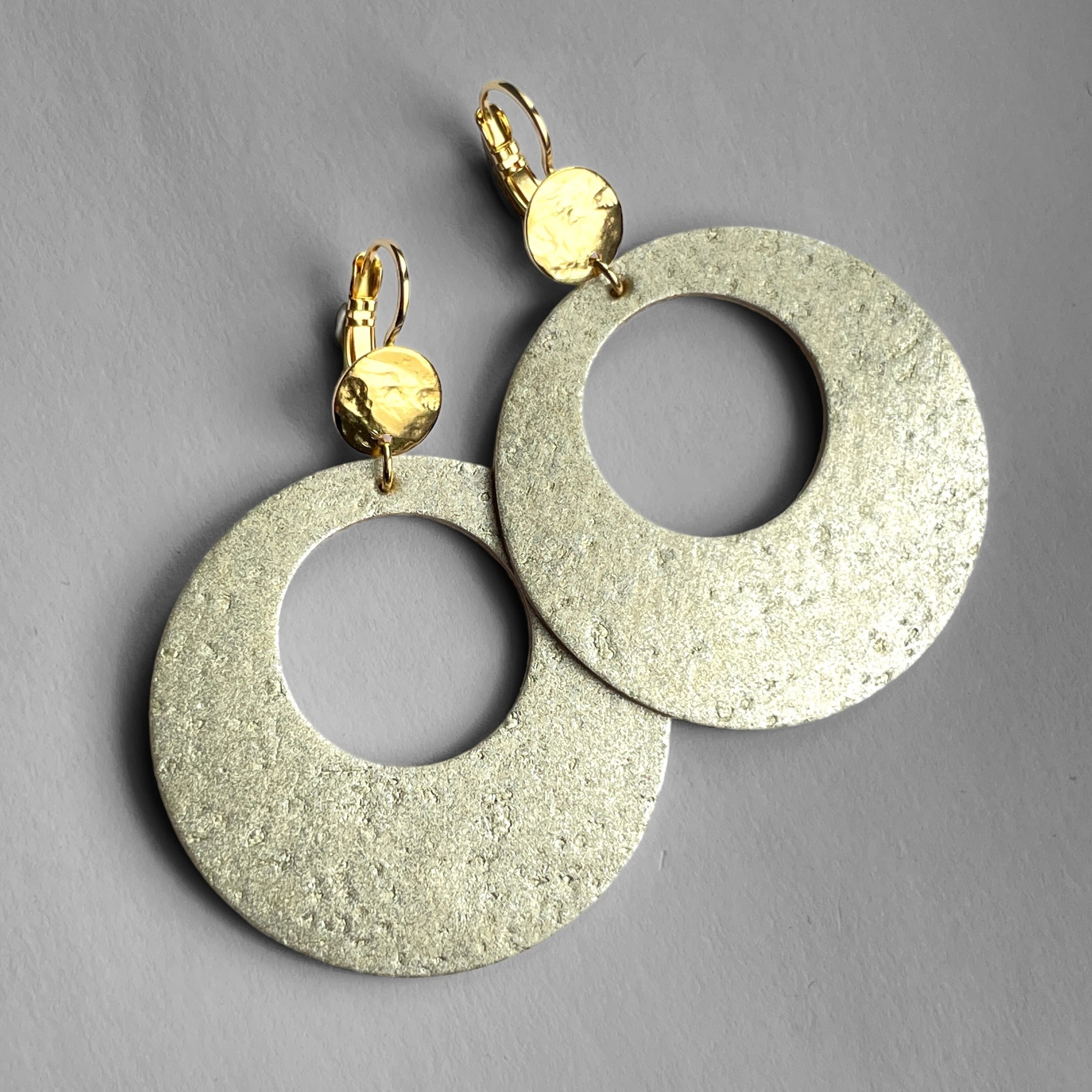 grandes boucles d'oreilles créoles Zoa au style vintage en liège doré antique, et dormeuses martelées dorées à l'or fin, sur fond gris