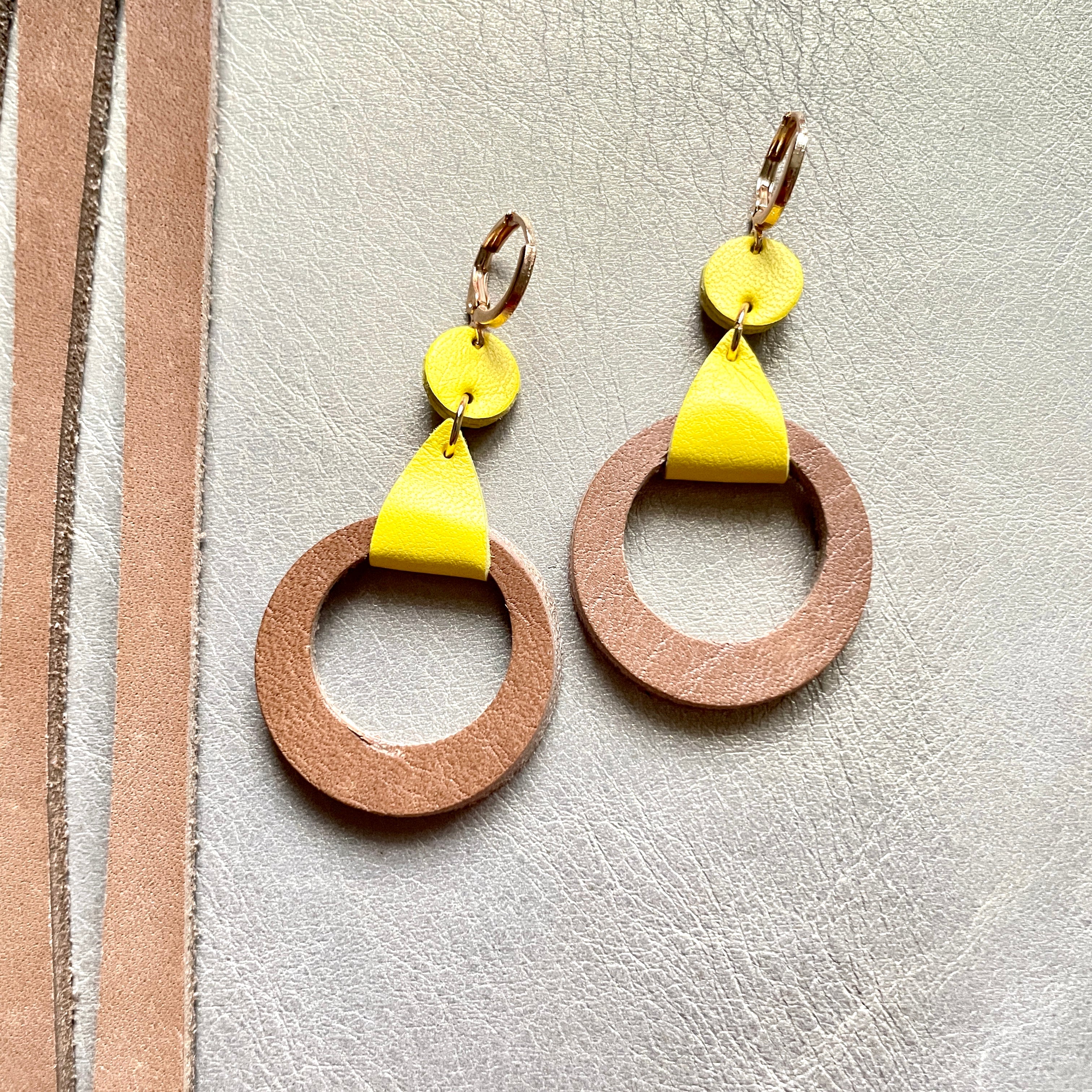 boucles d'oreilles dorées Nune modèle Cyllène en cuirs beige amande et jaune citron sur fond gris