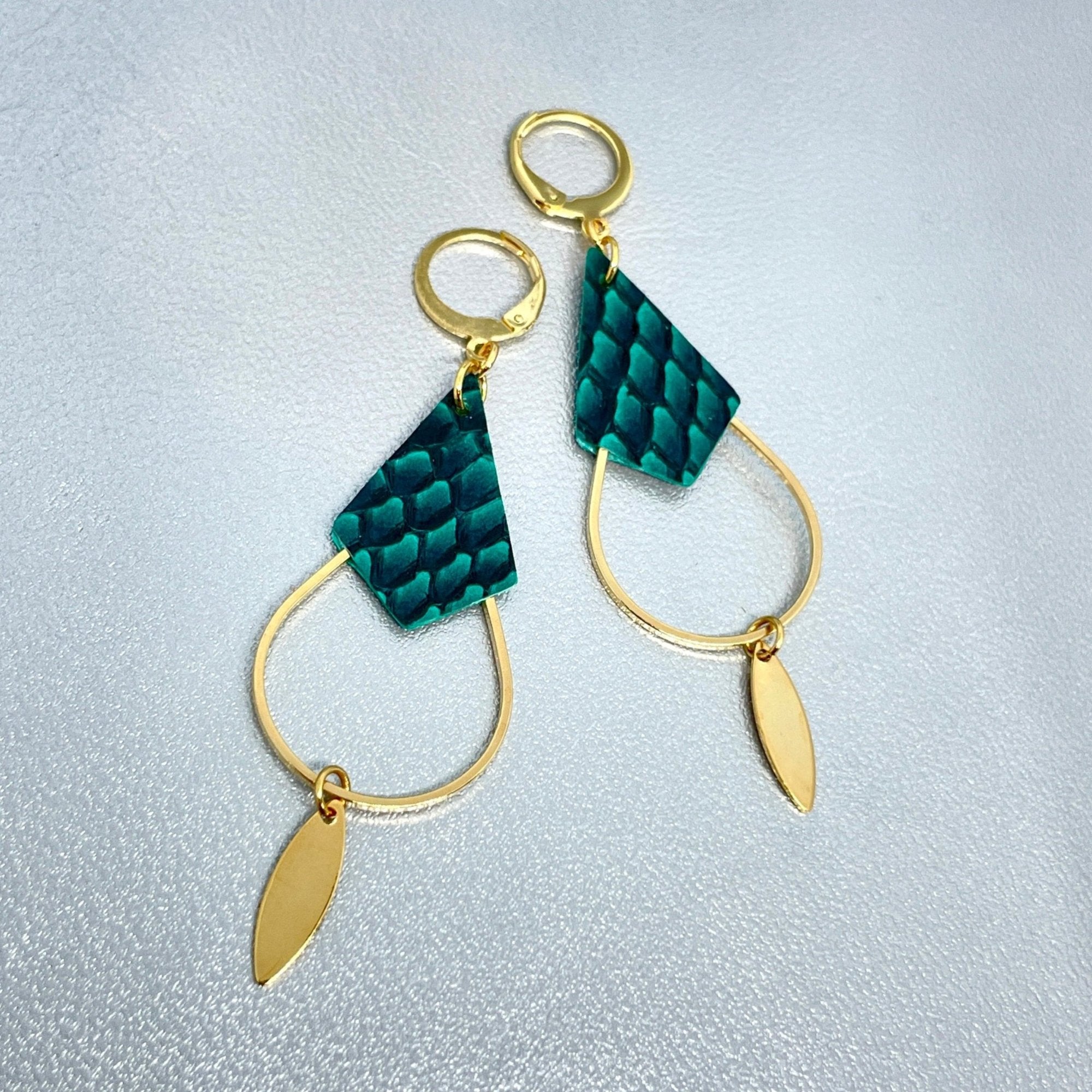 Boucles d'oreilles Gali de Nune, dorées à l'or fin avec triangle de cuir marin, cuir de poisson saumon vert émeraude écaille, de forme grande goutte, sur fond cuir gris argenté