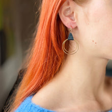 Charger l&#39;image dans la galerie, Boucle d&#39;oreille créole dorée Nune modèle Vega en cuir bleu nuit métallisé portée par un modèle aux cheveux roux
