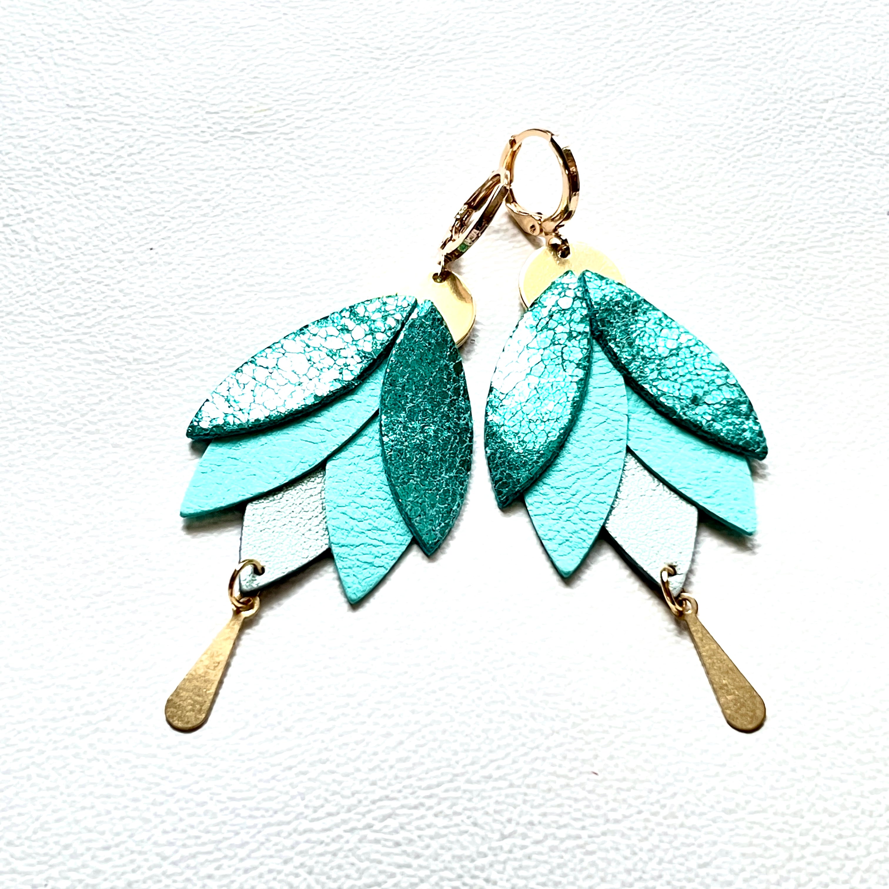 Boucles d'oreilles dorées pendantes Nune modèle Nymphéa en cuirs recyclés vert émeraude métallisé, vert menthe et bleu lune nacré, sur fond blanc
