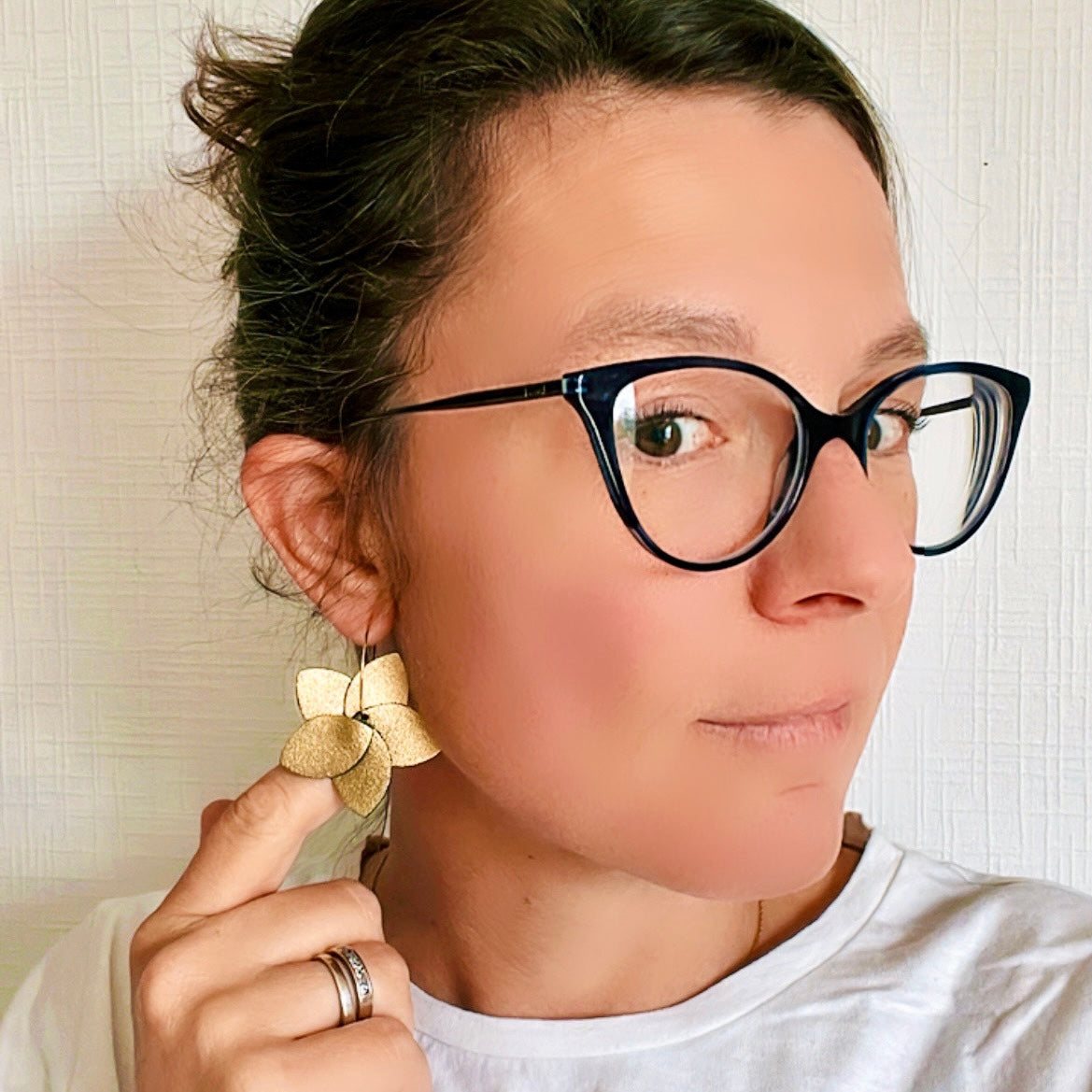 Nune boucle d'oreille créole Tiara en cuir doré satiné et anneaux dorés, portée à l'oreille