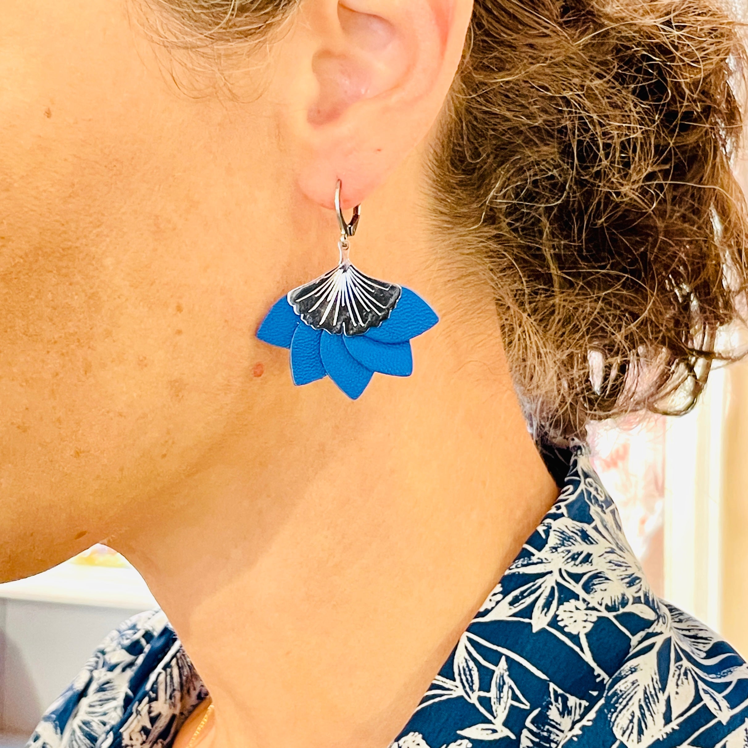 Boucle d'oreille argentée Nune modèle Ginka en pétales de cuir bleu roi, portées à l'oreille