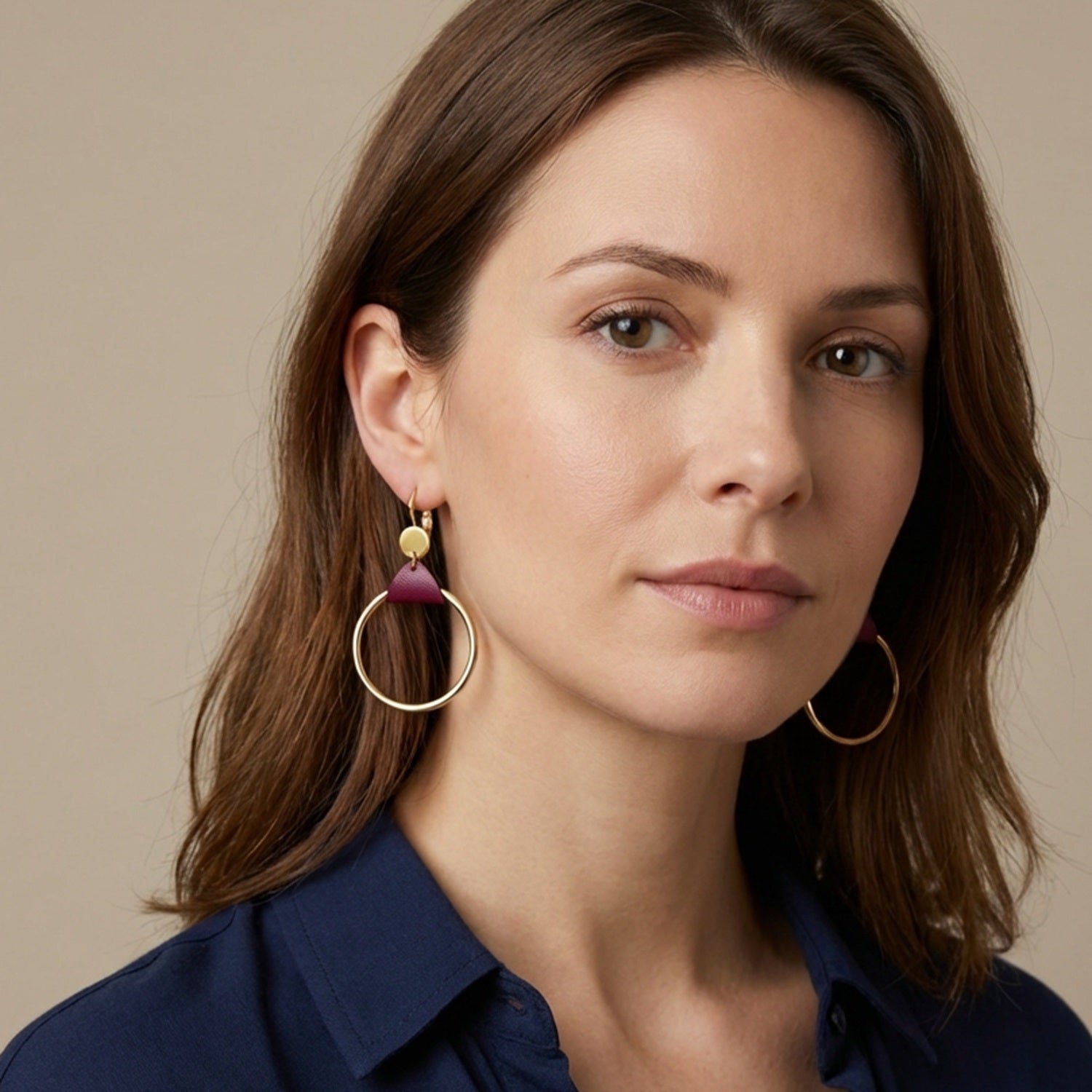 Femme brune portant les Boucles d'oreilles dorées Cléa, grands anneaux créoles, noués par un morceau de cuir pourpre aux accroches dormeuses