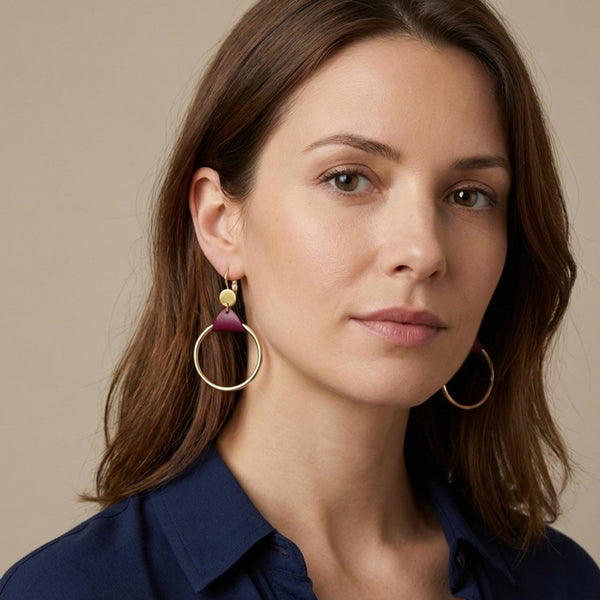 Femme brune portant les Boucles d'oreilles dorées Cléa, grands anneaux créoles, noués par un morceau de cuir pourpre aux accroches dormeuses