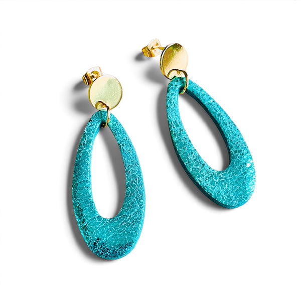 Puces d'oreilles dorées Drys de la marque Nune, avec leurs anneaux ovales en cuir vert émeraude brillant, sur fond blanc