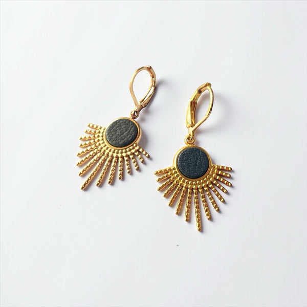 Petites boucles d'oreilles dorées Miria forme soleils avec cabochons de cuir noir grainé sur fond blanc