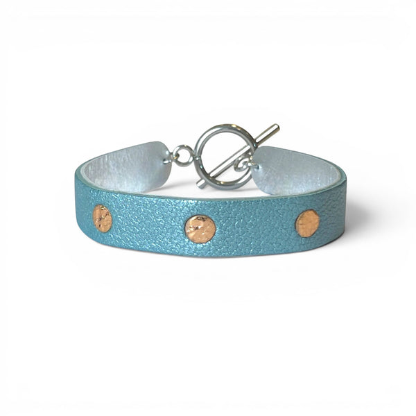 Bracelet argenté en cuirs bicolore bleu gris nacré et or rosé froissé, sur fond blanc