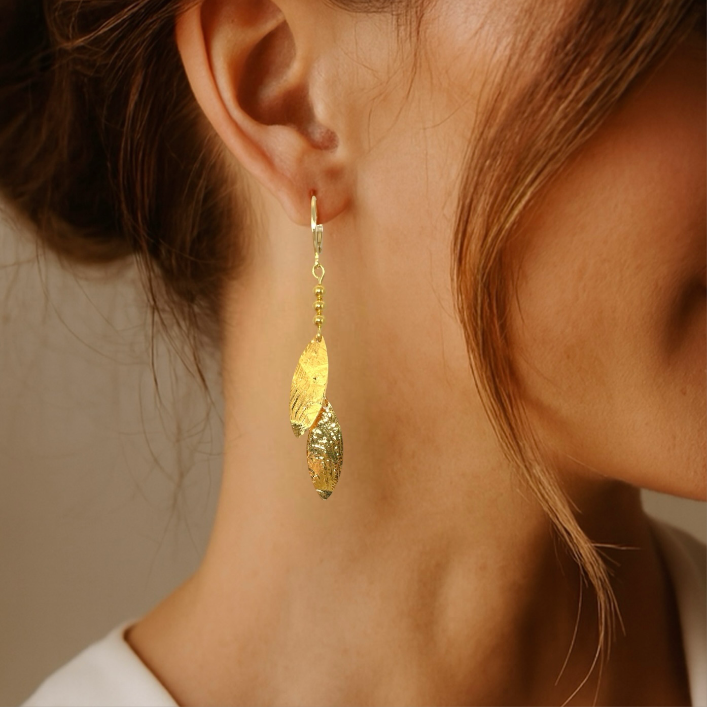 Longues boucles d'oreilles fines avec double pointes en métal martelé doré , portées aux oreilles