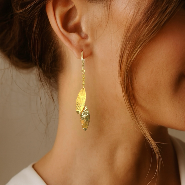 Longues boucles d'oreilles fines avec double pointes en métal martelé doré , portées aux oreilles