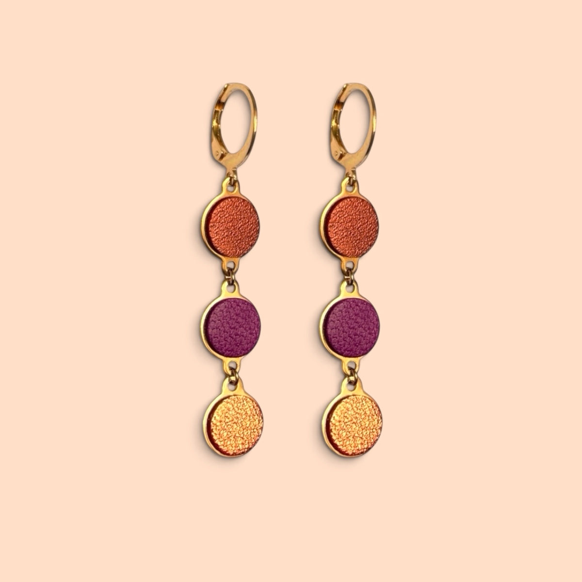 Boucles d'oreilles pendantes Cassia Nune en chapelet de trois sequins dorés et cuirs upcyclés cuivre clair, pourpre et terracotta métallisé, avec dormeuses dorées
