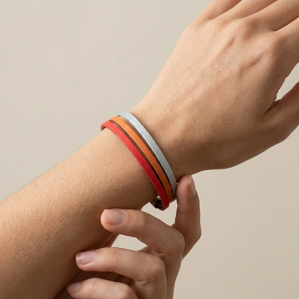Cielo Bracelet femme tricolore à 3 liens avec fermoir aimanté argenté, en cuirs saumon, orange mandarine et gris métallisé, présenté porté au poignet, sur fond blanc