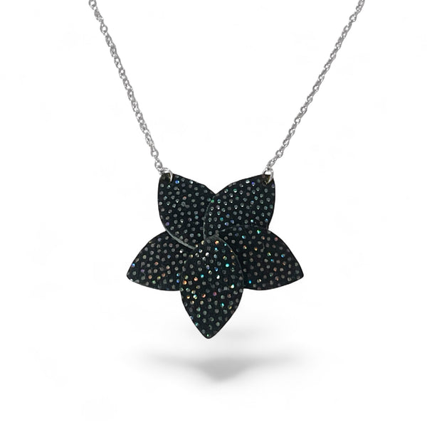 Collier argenté court avec pendentif en cuir noir à pois holographiques en forme de fleur, sur fond blanc