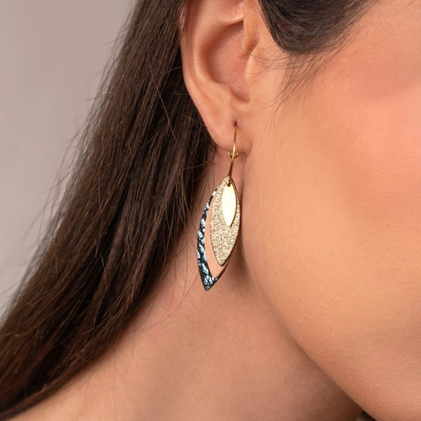 Boucles d'oreilles créoles dorées Nune modèle Piume en cuirs cannelle dorée satinée, rose pâle et bleu glacier métallisé grainé, portées à l'oreille et vues en gros plan