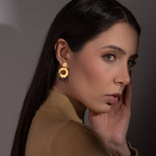 Charger l&#39;image dans la galerie, Petites boucles d&#39;oreilles créoles à puces de forme ronde en métal martelé doré à l&#39;or fin et pierres naturelles améthystes, portées à l&#39;oreille par une femme brune
