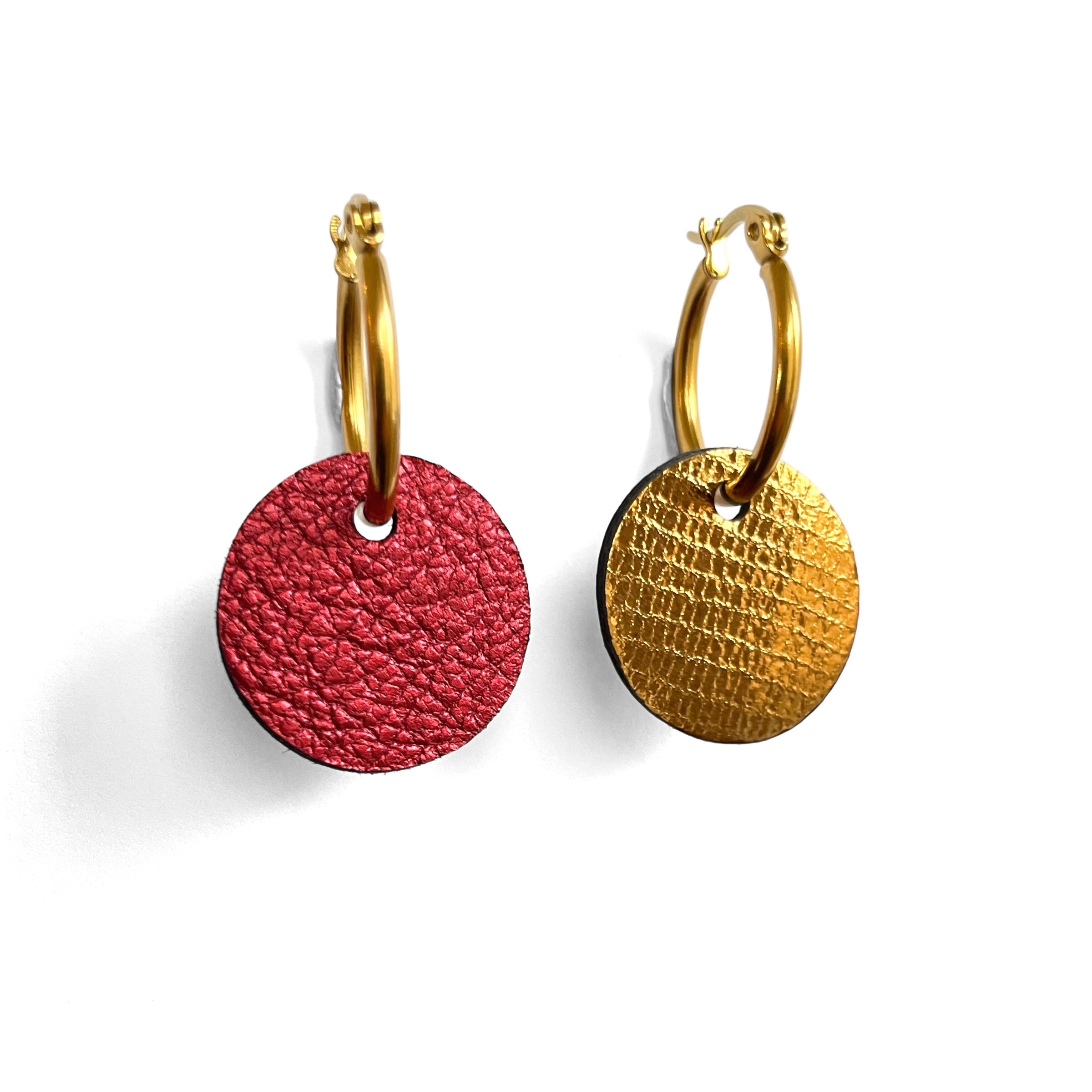 boucles d'oreilles créoles dorées, réversibles avec disque de cuir rubis métallisé au recto et bronze brillant façon serpent au verso, vues de biais, sur fond blanc