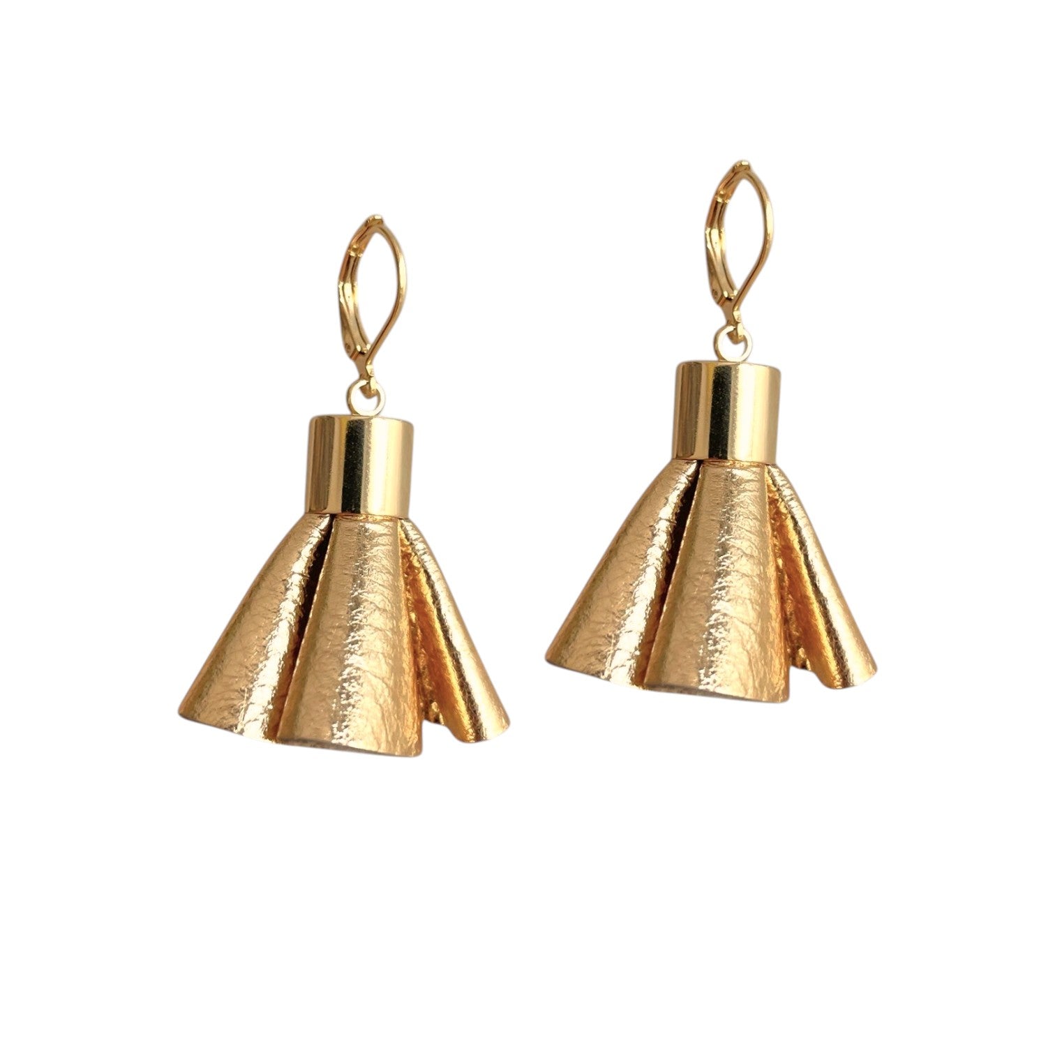 Boucles d'oreilles dorées en pompons frou frou de cuir doré, debout sur fond blanc