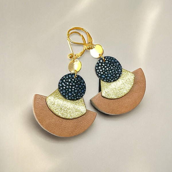 boucles d'oreilles dorées Nune modèle Hestia en cuirs beige amande, bleu nuit grainé irisé et doré satiné sur fond gris clair
