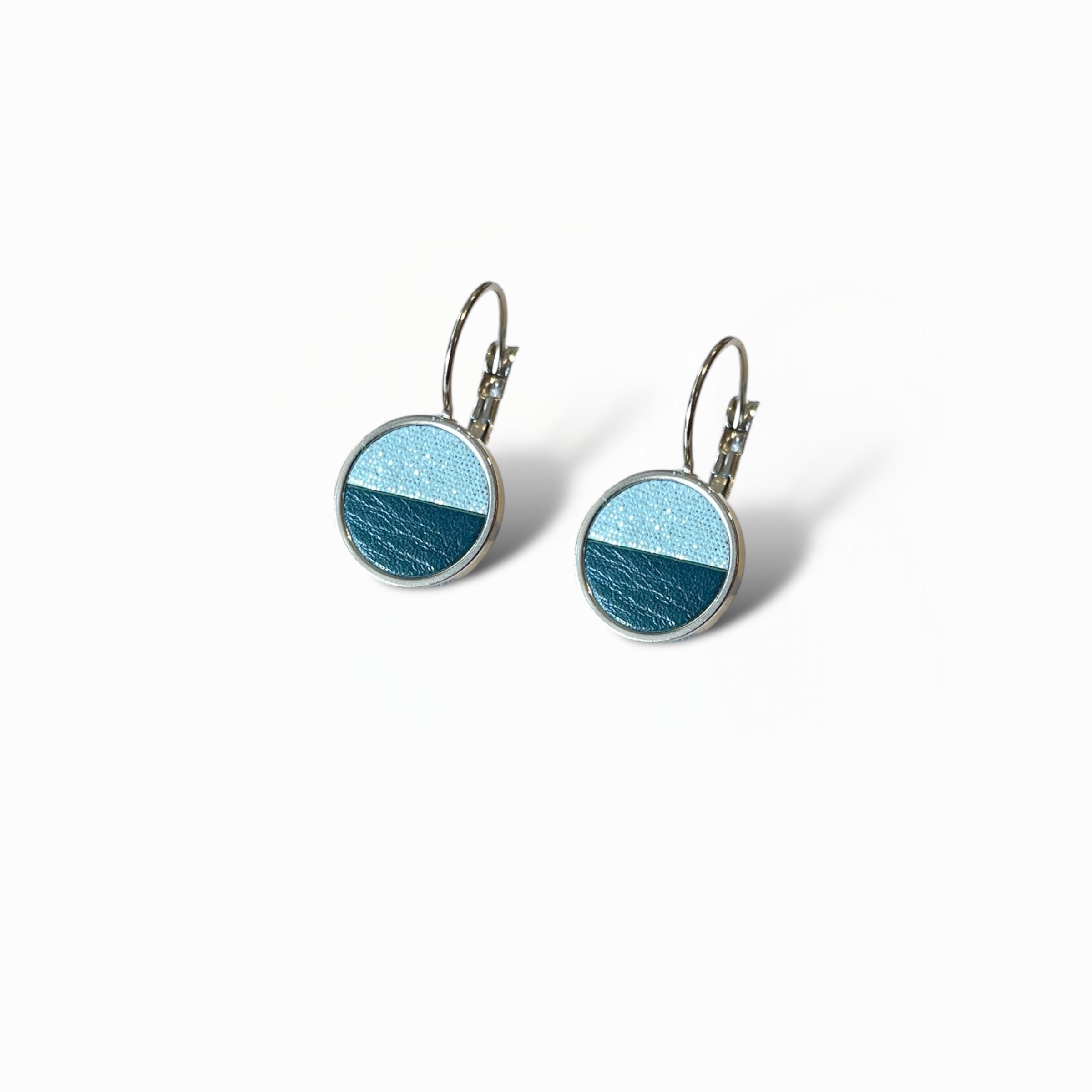 Petites boucles d'oreilles argentées pendantes rondes avec un duo de cuirs topaze pailleté et vert canard en cabochon sur fond blanc