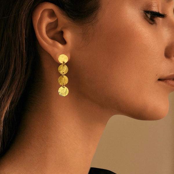 Fines puces d'oreilles pendantes en chapelet de 4 petits sequins ronds en métal martelé doré à l'or fin, portées aux oreilles