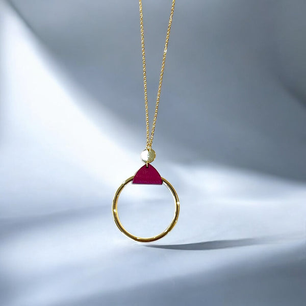 Collier fin dorée avec pendentif grand anneau créole attaché par une fine pièce de cuir pourpre, sur fond gris