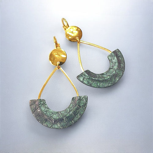 Boucles d'oreilles Anoush de Nune, dorées à l'or fin avec cuir marin, cuir de poisson saumon gris irisé, en forme de demi-lune, sur fond gris