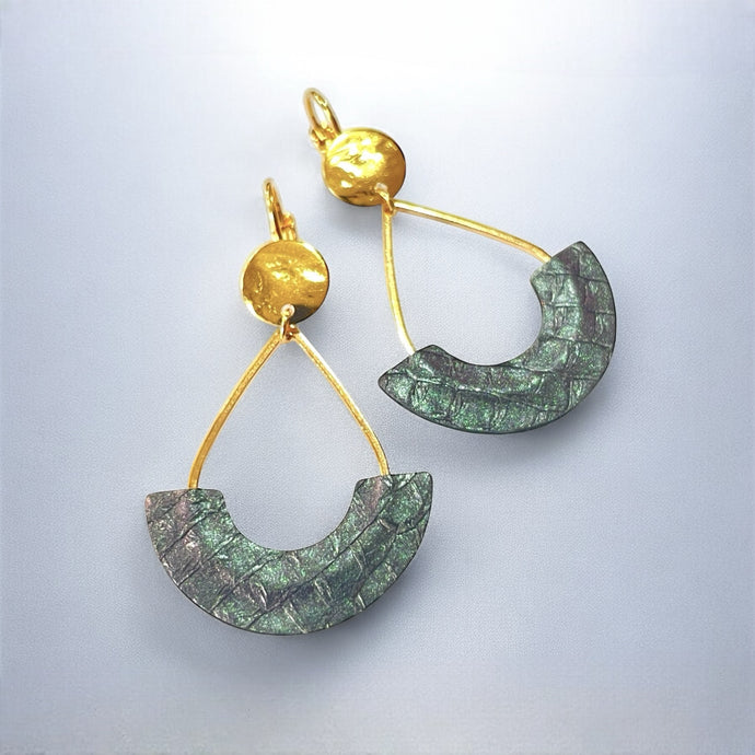 Boucles d'oreilles Anoush de Nune, dorées à l'or fin avec cuir marin, cuir de poisson saumon gris irisé, en forme de demi-lune, sur fond gris