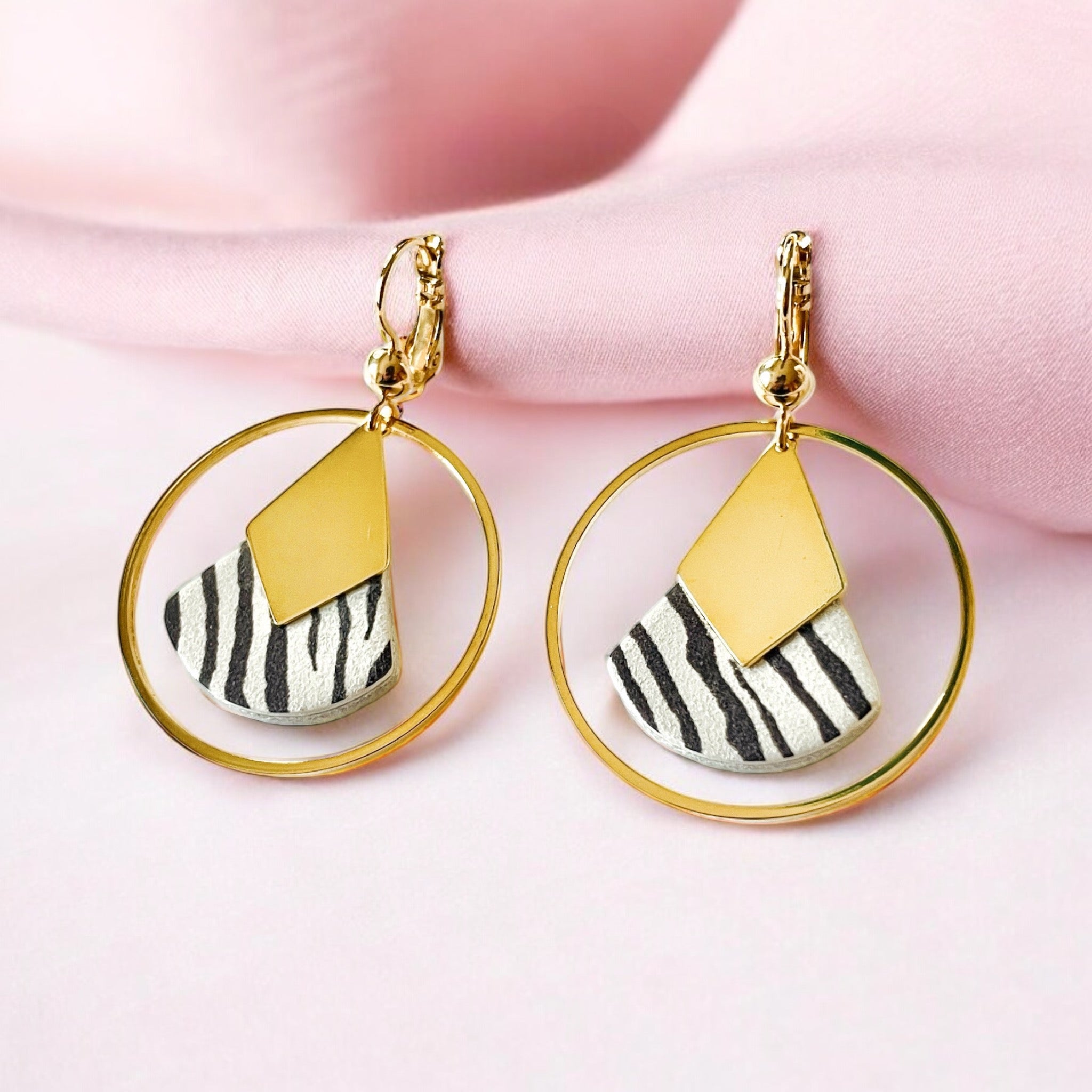 Boucles d'oreilles dorées à l'or fin Nune modèle Scala Créoles en cuir zébré noir sur fond tissu rose pastel