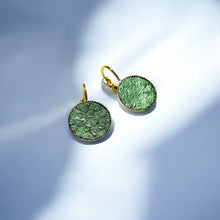 Charger l&#39;image dans la galerie, Petites boucles d&#39;oreilles dormeuses dorées serties de fin cuir marin vert bouteille métallisé, sur fond bleu
