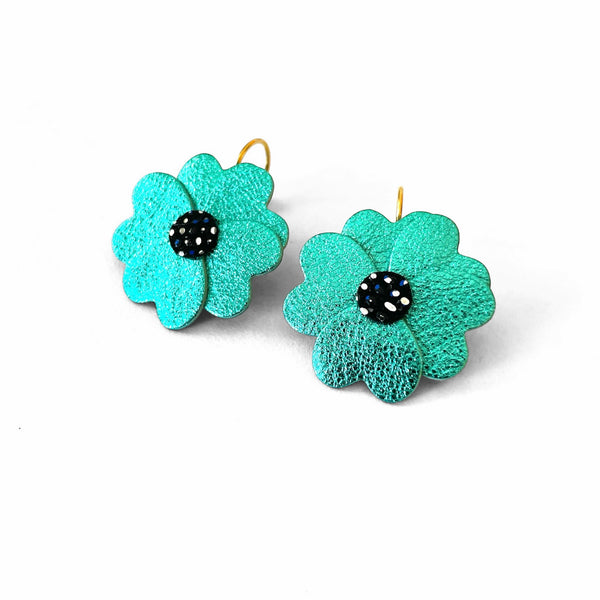 Boucles d'oreilles Nune en forme de petites fleurs , modèle Lalie, en cuirs turquoise métallisé & noir à pois argentés et bleus sur fond blanc