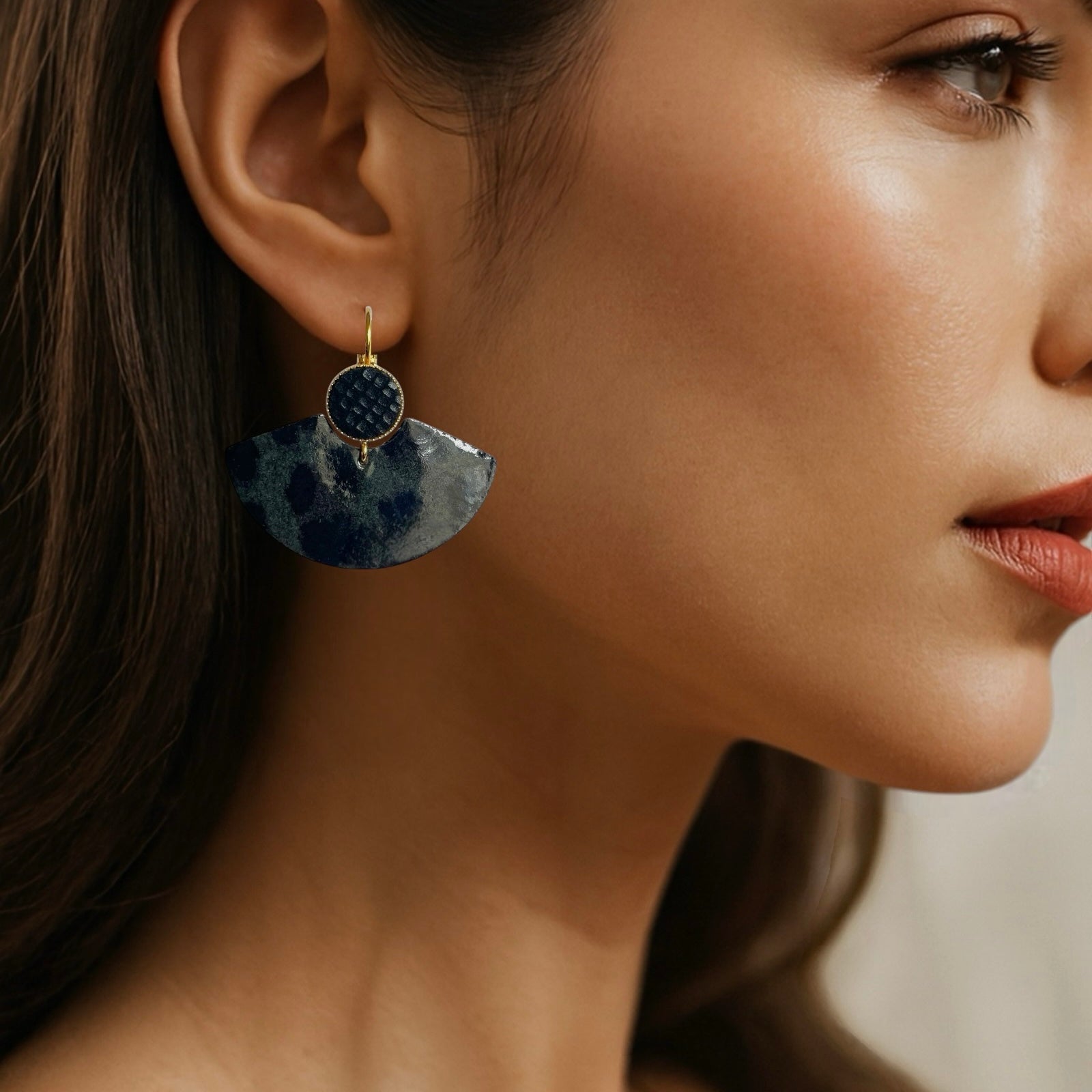 Boucles d'oreilles dorées pendantes, en forme d'éventails japonais en cuirs noir grainé irisé et léopard noir vernis , portées aux oreilles