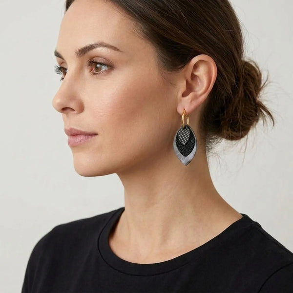 Créoles dorées avec pendentifs modulables en forme de feuilles en cuirs noir petit grain irisé, noir grainé pailleté et léopard noir vernis portees