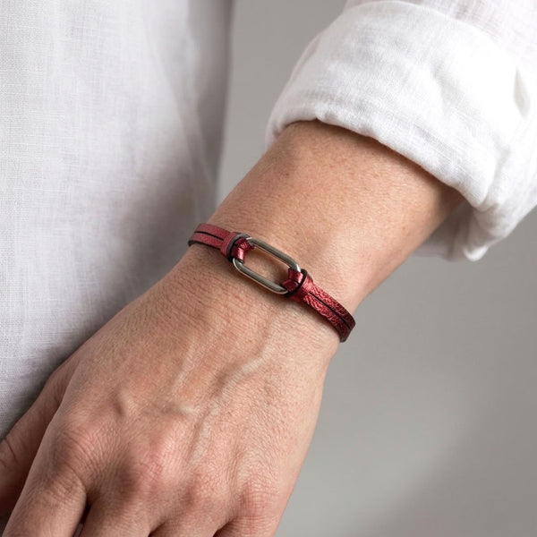 Bracelet femme à boucle argentée en fins liens de cuir grenat métallisé, avec fermoir aimanté argenté au poignet