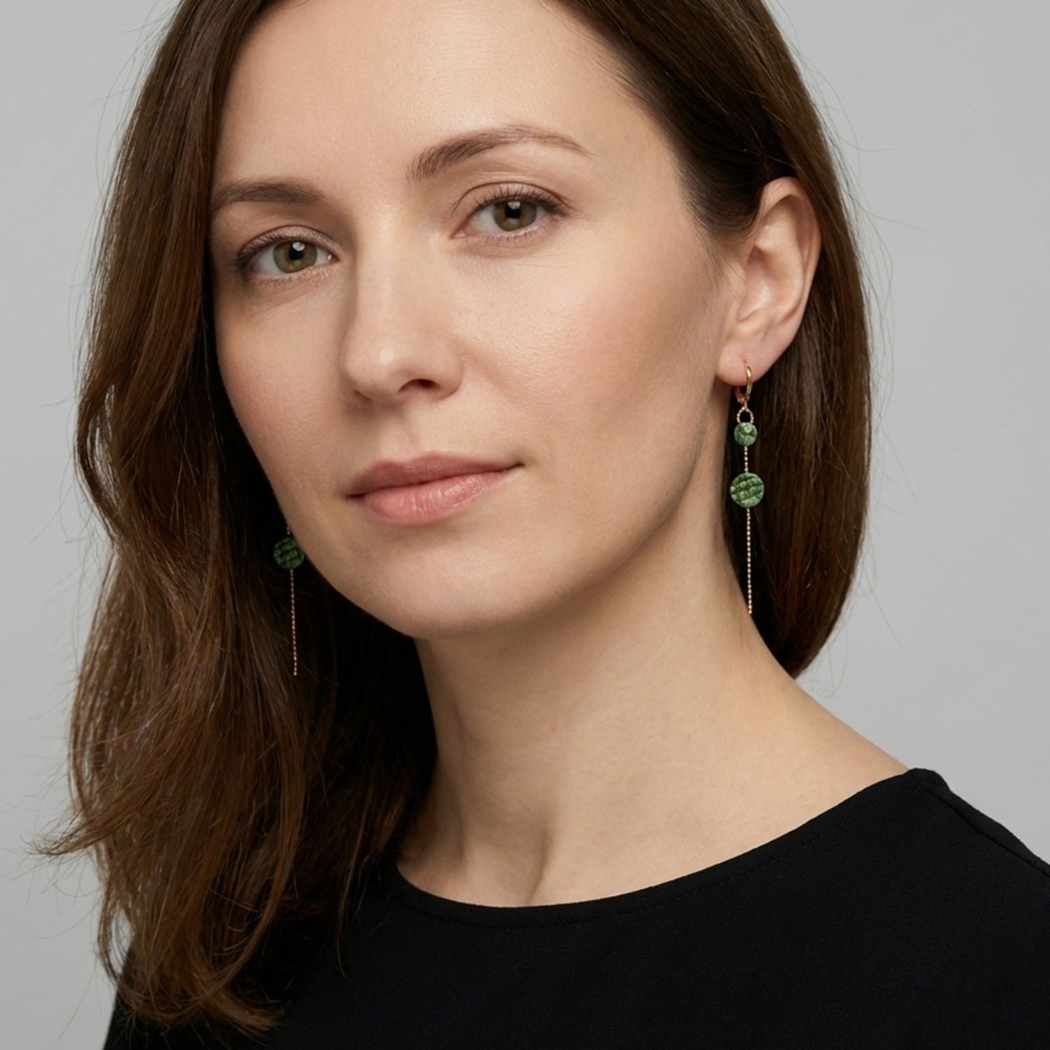 boucles d'oreilles fines dorées l'or fin cuirs marin kaki métallisé portées par une femme brune