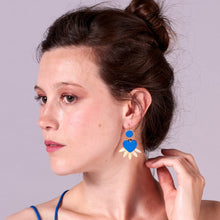 Charger l&#39;image dans la galerie, Visage de jeune femme à chignon, vue de profil, portant les Boucles d&#39;oreilles dorées Vénus en forme de cœurs style ex-voto en cuir bleu roi recyclé
