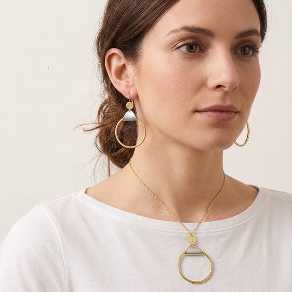 Parure dorée Cléa avec pendentif anneau et liège argent - Collier et boucles d'oreilles portées par une femme brune