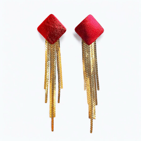 Puces d'oreilles losanges en cuir rouge métallisé avec leurs cascades de fines chaînettes dorées, sur fond blanc