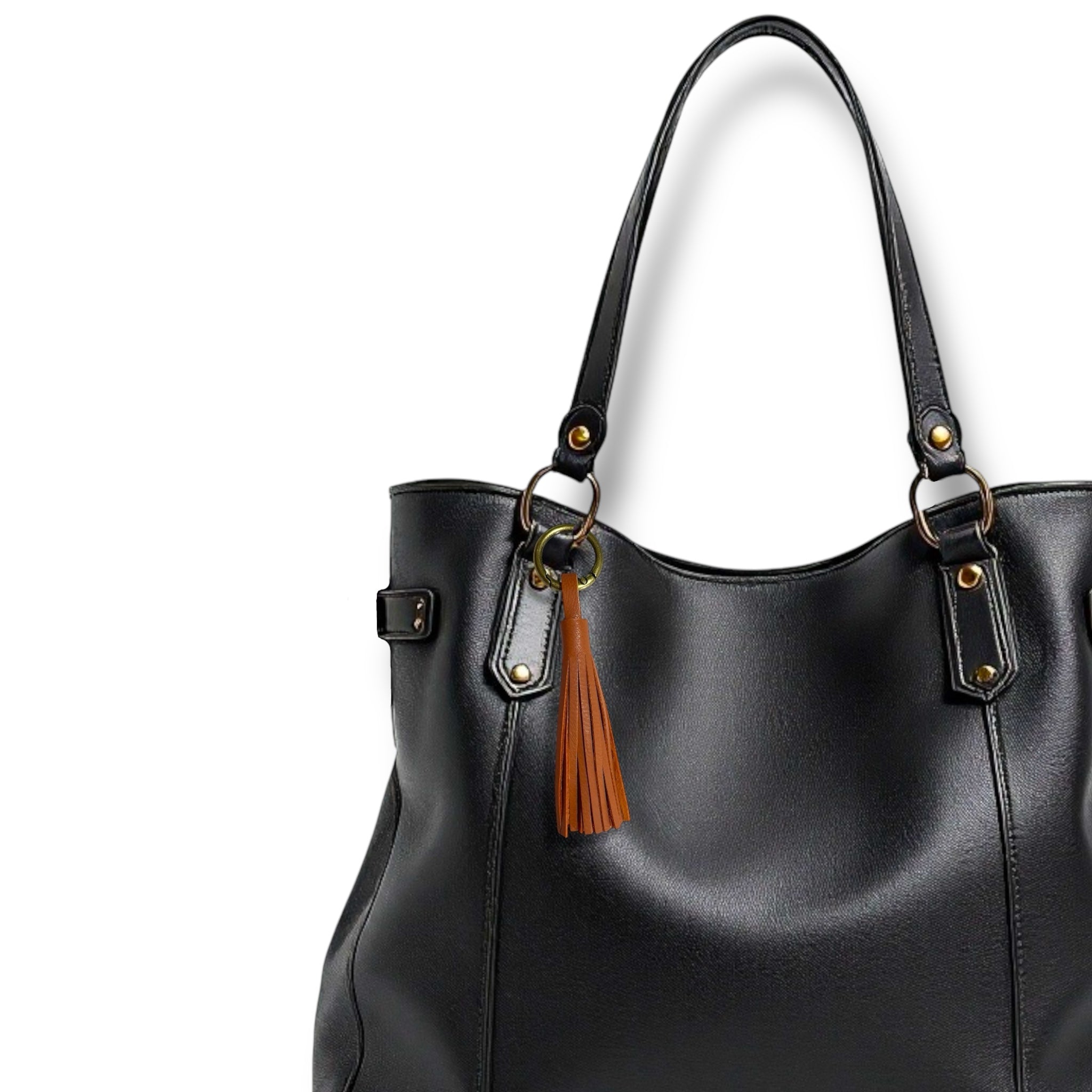 Bijou de sac bronze,  portant un grand pompon en cuir terracotta, sur un sac en cuir noir