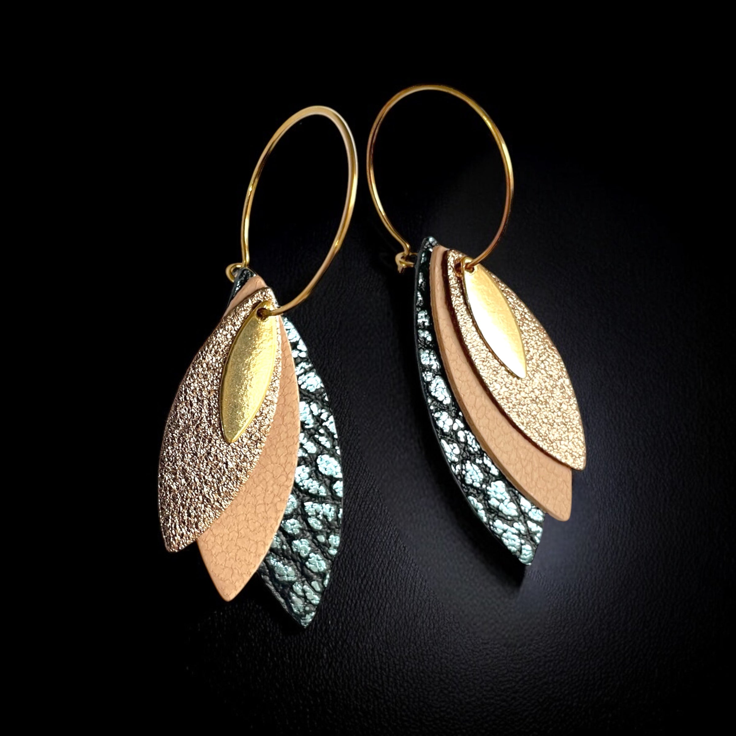Boucles d'oreilles créoles dorées Nune modèle Piume en cuirs cannelle dorée satinée, rose pâle et bleu glacier métallisé grainé, sur fond noir