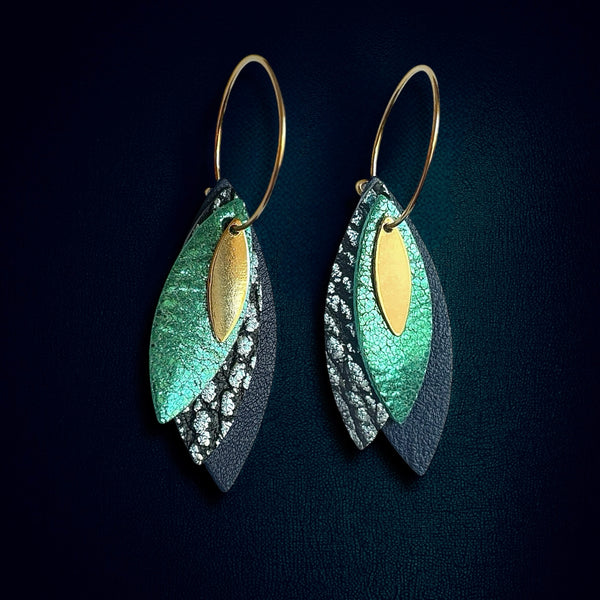 Boucles d'oreilles créoles dorées Nune modèle Piume en cuirs émeraude, bleu glacier métallisé et bleu marine, sur fond bleu nuit