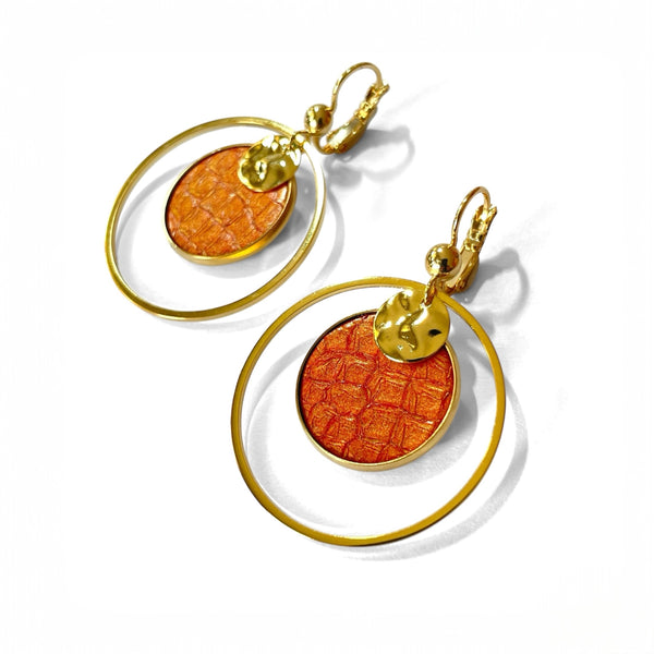Paire de boucles d'oreilles dorées rondes pendantes de style créoles avec sequin en cuir marin orangé or, vue de côté, sur fond blanc