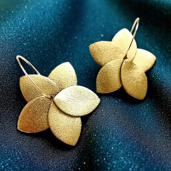 boucles d'oreilles créoles Tiara en cuir doré satiné et anneaux dorés, sur fond cuir vert canard pailleté or