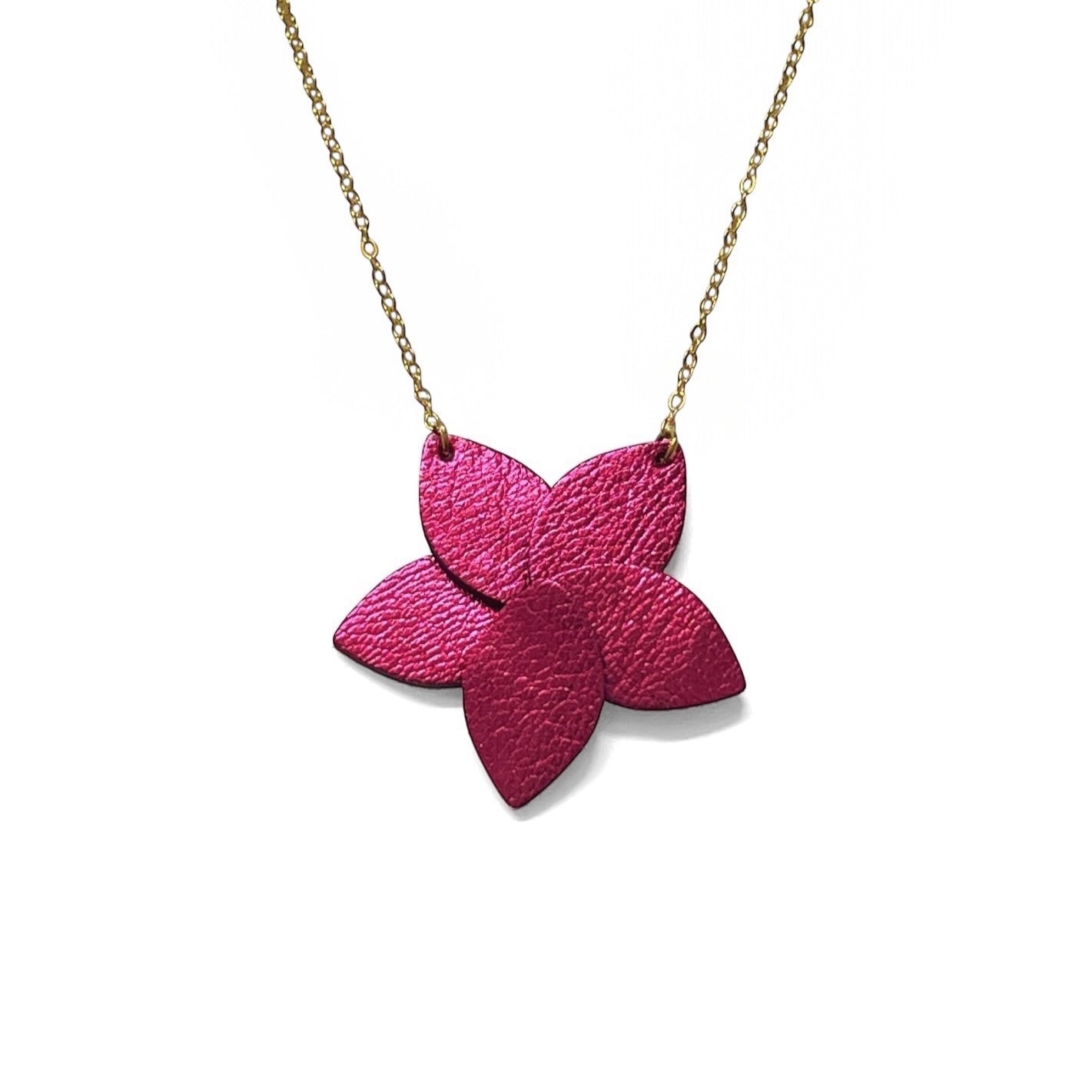 Collier doré court avec pendentif en cuir fushia métallisé en forme de fleur, sur fond blanc