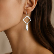 Charger l&#39;image dans la galerie, Boucles d&#39;oreilles argentées avec pendentif en forme de losanges et pointes, portées aux oreilles 
