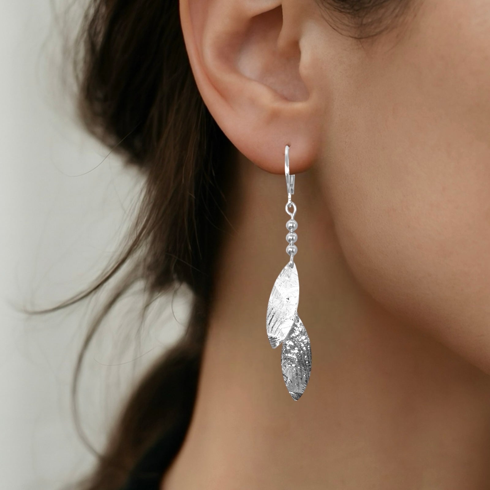 Longues boucles d'oreilles fines avec double pointes en métal martelé argenté, portées aux oreilles