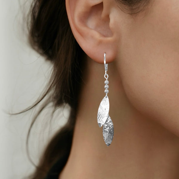Longues boucles d'oreilles fines avec double pointes en métal martelé argenté, portées aux oreilles