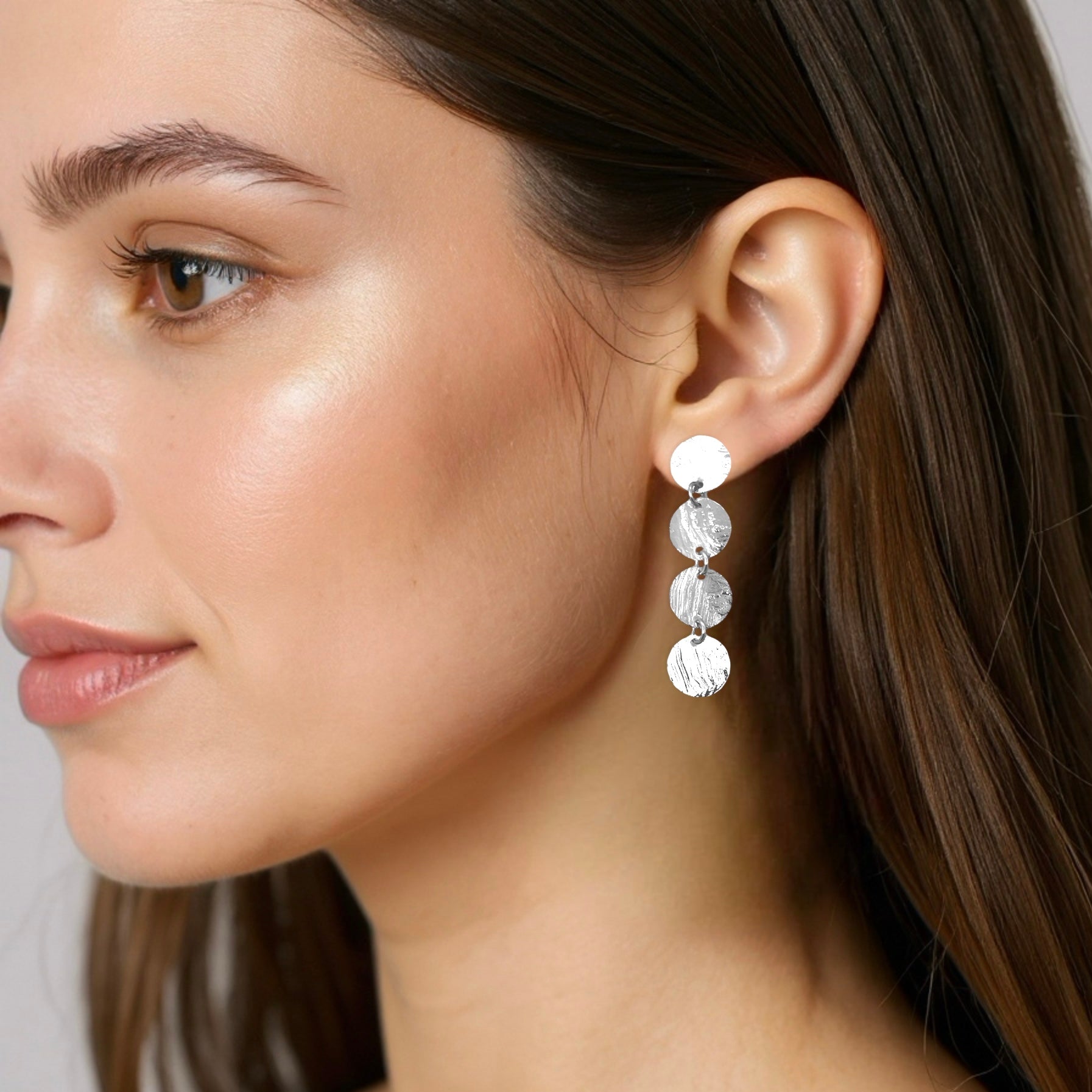 Fines puces d'oreilles pendantes en chapelet de 4 petits sequins ronds en métal martelé argenté, portées aux oreilles