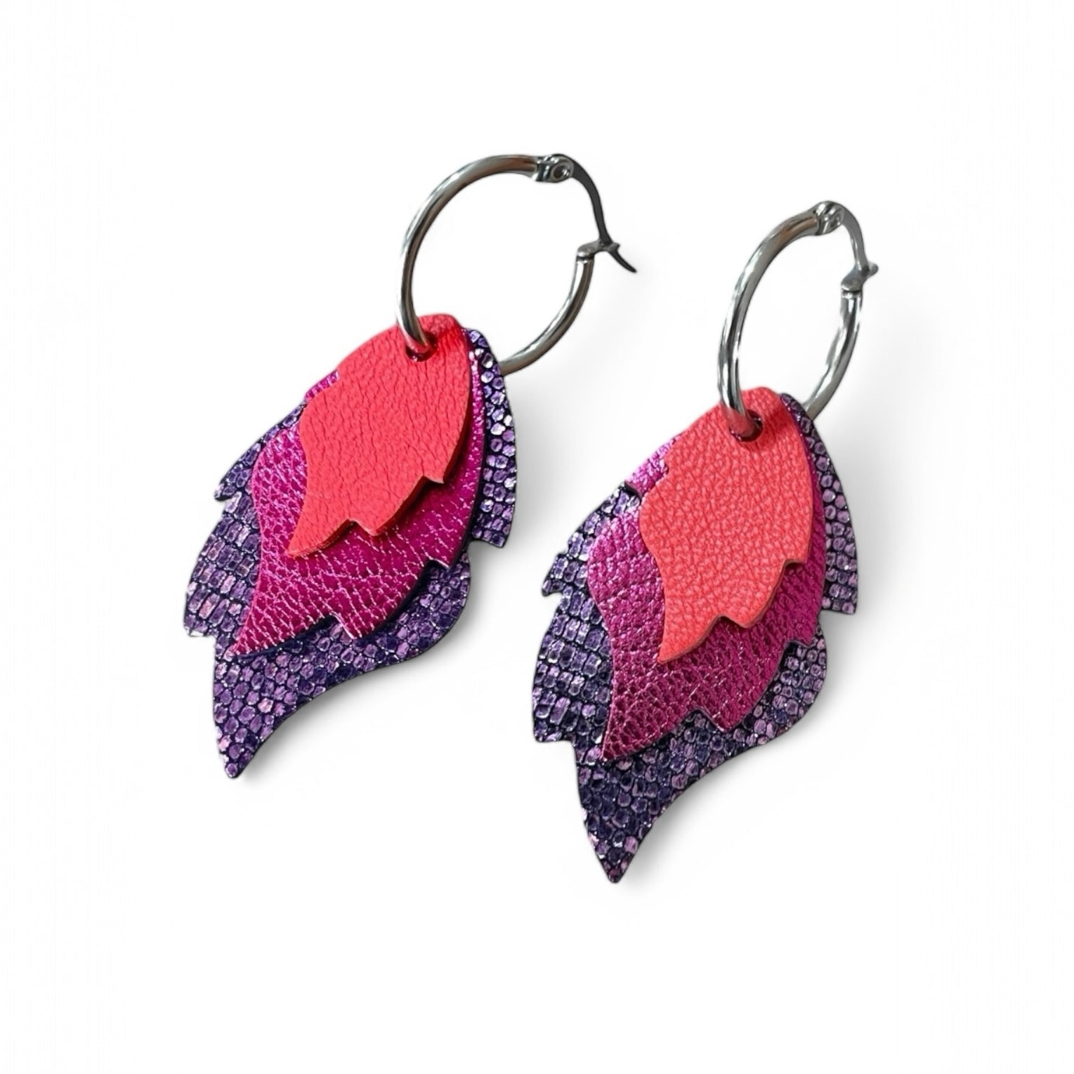 Créoles dorées avec 3 pendentifs modulables en forme de flammes en cuirs saumon, fushia métallisé et violet brillant façon serpent, sur fond blanc