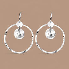 Charger l&#39;image dans la galerie, Grandes boucles d&#39;oreilles créoles argentées avec sequins en métal martelé, avec attaches-dormeuses, sur fond beige
